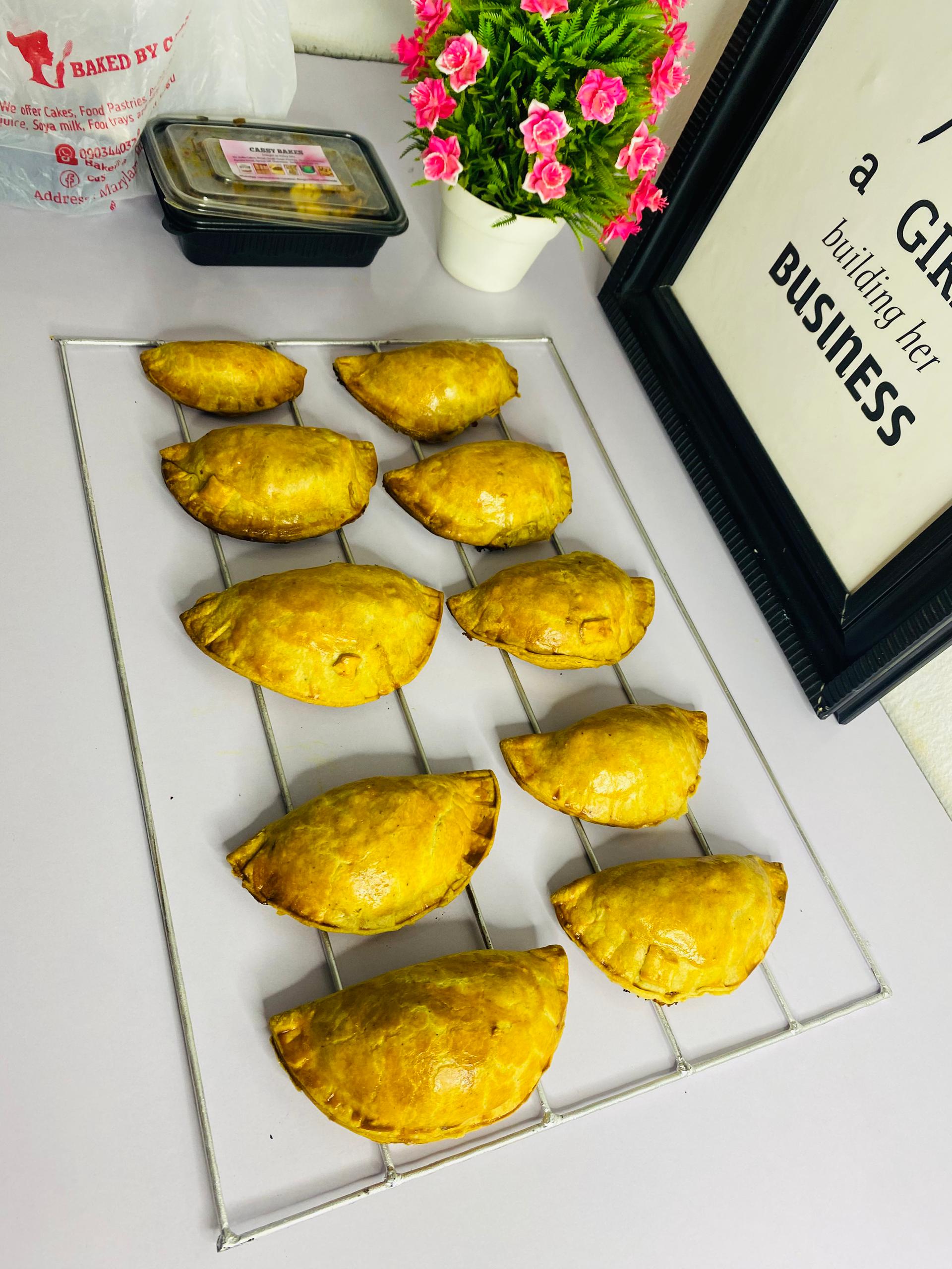 Fresh golden meat pies on cooling rack