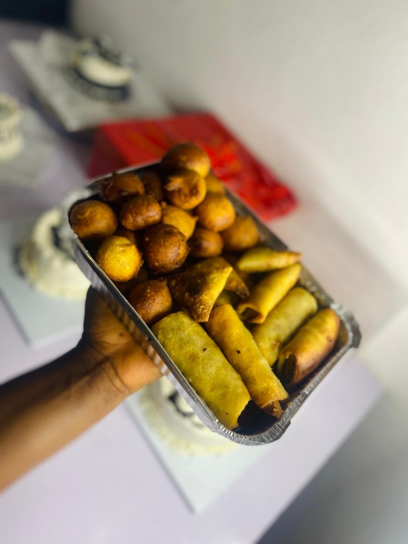 Spring rolls and puff-puffs combo in foil tray